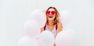donna felice circondata da palloncini rosa