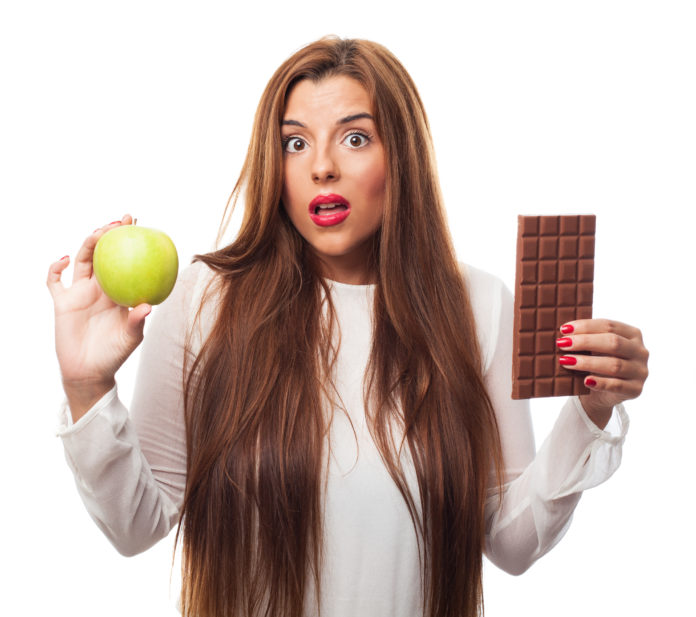 donna con in mano una mela e una tavoletta di cioccolato