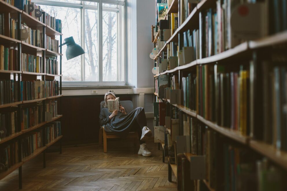 donna legge in biblioteca